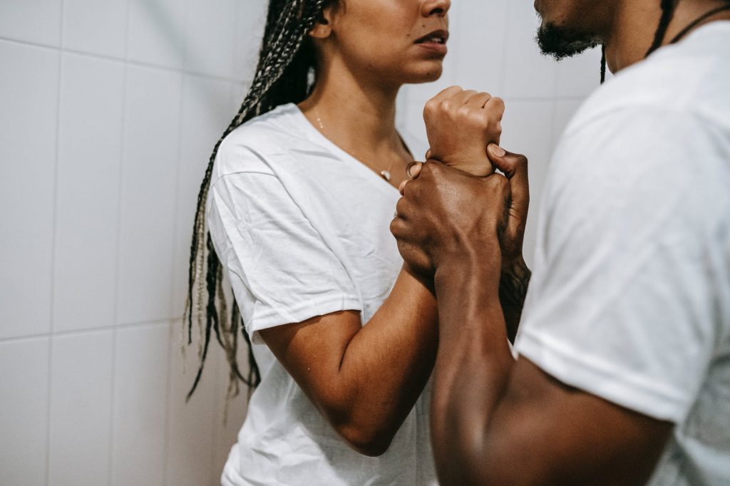 crop anonymous black couple arguing together in bathroom