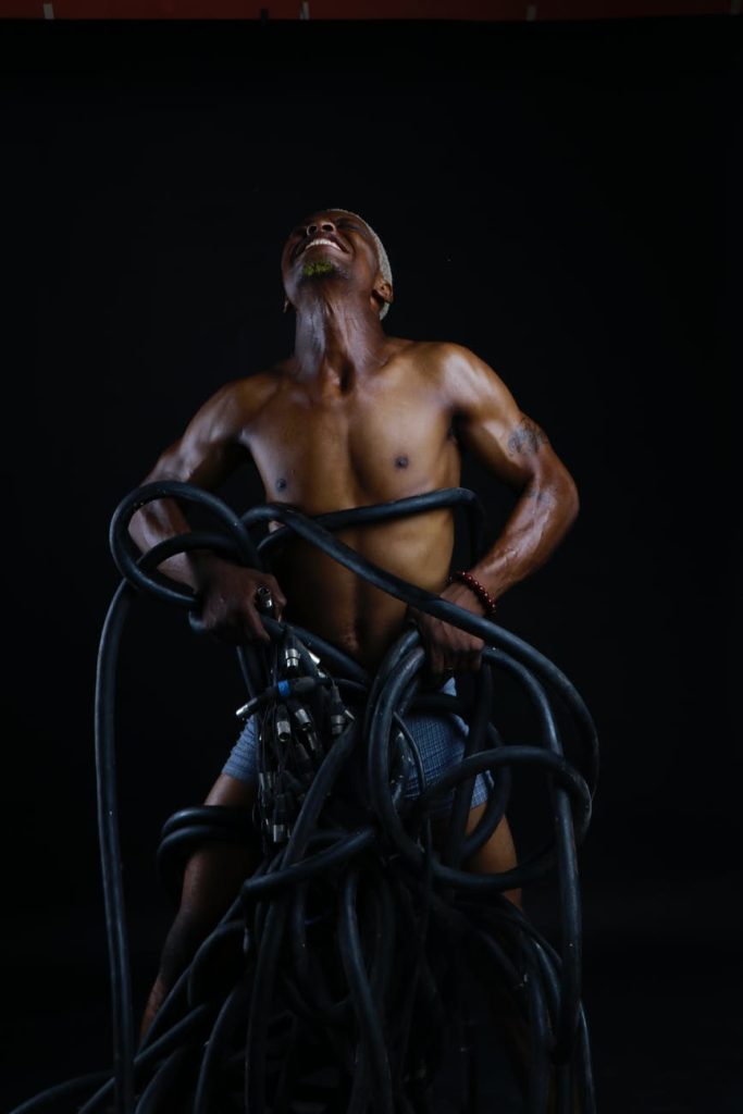 shirtless black man fighting with ropes in studio