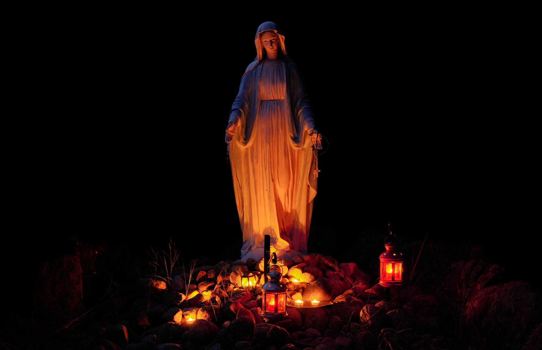 statue of a virgin mary lighted by candles