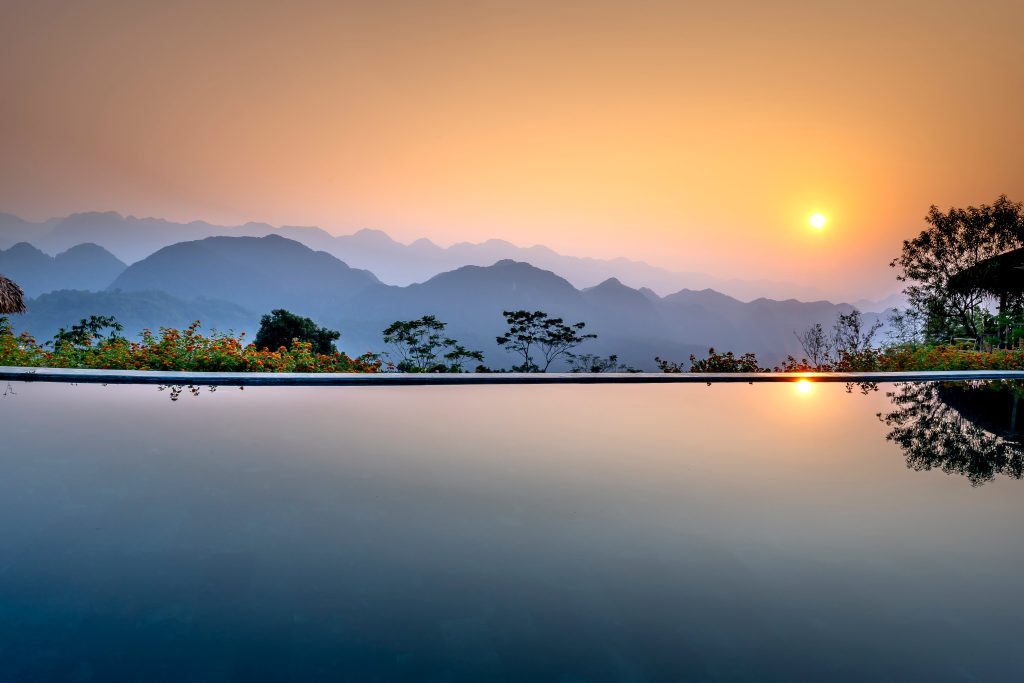 Enchanting sunrise over a tranquil mountain lake with misty reflections.